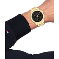 Tommy Hilfiger Herenhorloge TH1792109 Troy met goudkleurige kast en zwarte wijzerplaat, gedragen om pols. Stijlvol accessoire voor elke outfit.